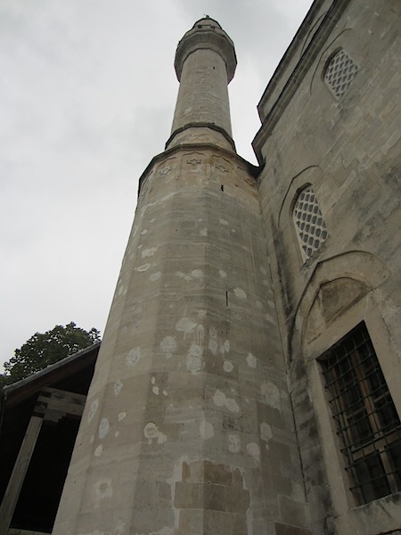 Patched shrapnel or bullet splats on mosque minaret.