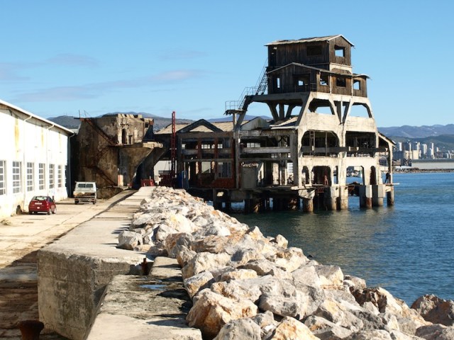 The breakwater running along the side of the factory and the 1930s torpedo test launching structure in the distance. 