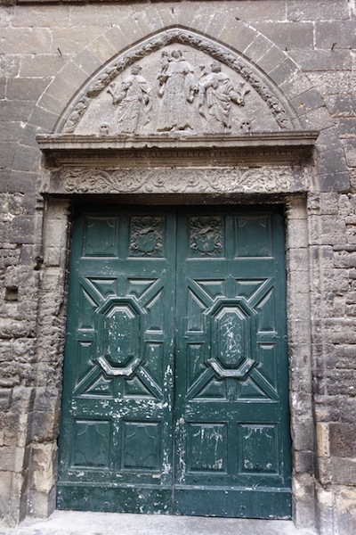 What’s behind the green doors? And what is the story depicted in the bas relief above the door?