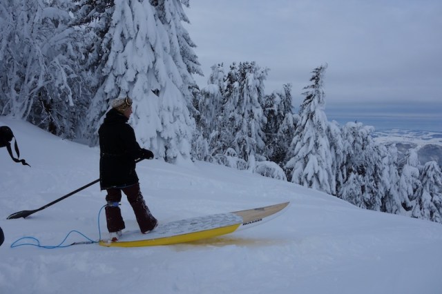 This dude lugged his surfboard to the top of the mountain and is about to plunge headlong down. 