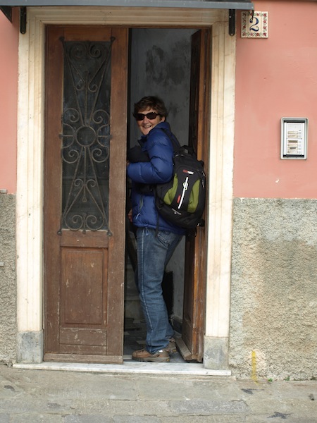 Bev squeezing through the front door of the apartment. 