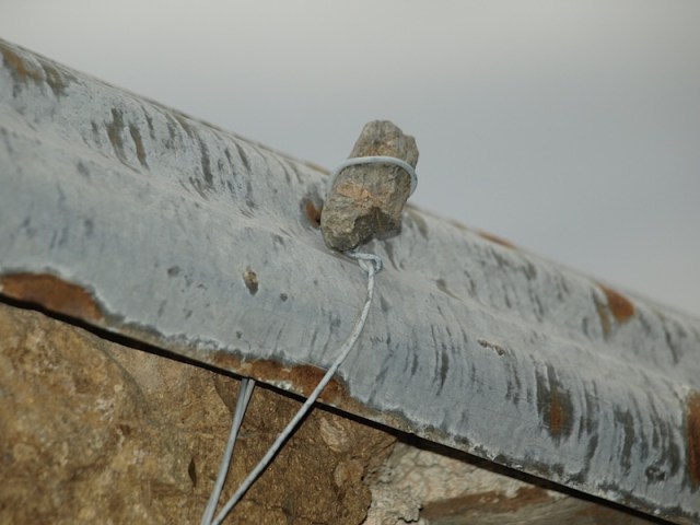 Securing a corrugated iron roof. 