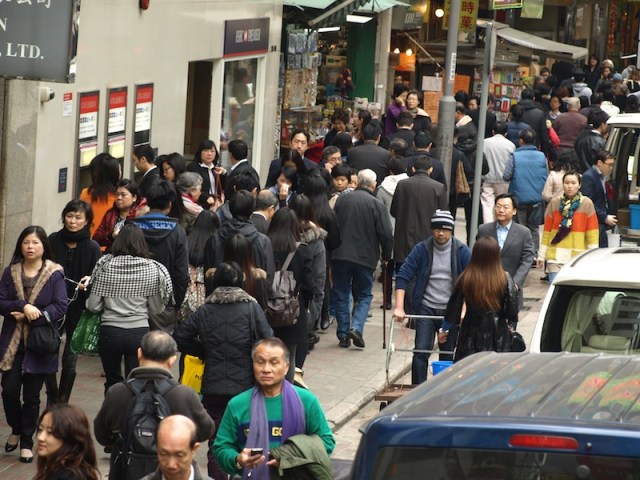 A few of the millions in Hong Kong. In many places the footpaths are not wide enough and pedestrians spill onto the roadway. 