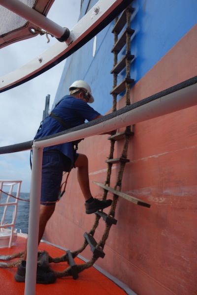 Alongside and the pilot boat deckhand testing the ladder prior to the pilot coming down.