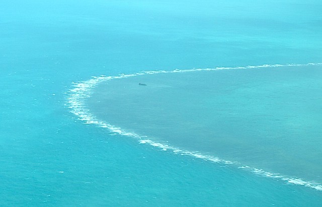 A ship (speck in the middle of photograph) stuck on a reef. Sorry for the poor quality picture but it was the best I could do under the circumstances. 