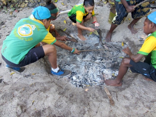 Having fun searching for the fired pottery pieces in the ashes. 