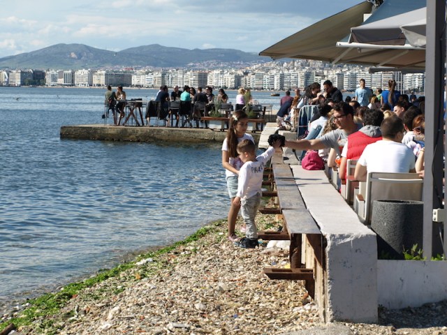 Enjoying the sun, taking in wine, coffee and conversation. Anywhere there is a flat spot by the sea tables and chairs are set up.