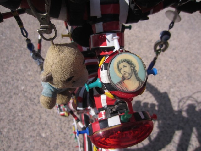 Close up of the bells and whistles bike. Protector Jesus and Tbear’s Greek cousin hitching a ride.