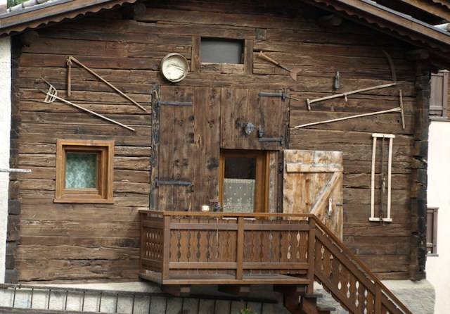Traditional house of the Livigno area. Farmers’ tools of trade consigned to the museum wall. 