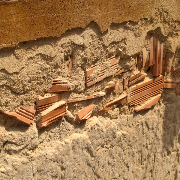 A wall made from rubble and a low-grade earth cement mix. Stucco covers the sins of the builder here. 