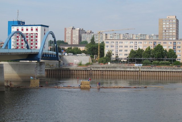 View across the Oder River towards Germany from Slubice, Poland. Frankfurt (Oder) is on the far bank. Note the adventurers on a bamboo raft passing under the bridge. 