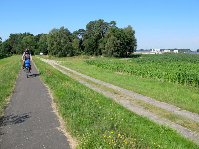 The D12 bike path running along the top of the river levee. I suspect the concrete road at lower level was where a border fence once ran. 