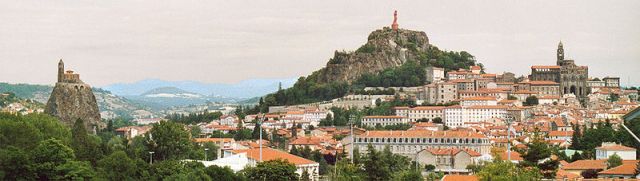 The old town of Le Puy. Chapel of Saint Michel d’Aigulhe (left). Protective Virgin statue (middle). Image by Patrick Giraud from Wikipedia. 
