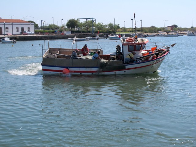 Fishing boat with a list to starboard going off to work
