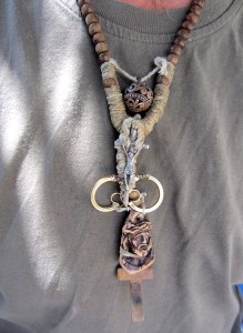 The earrings of the typist’s mother is part of a necklace around his neck. 