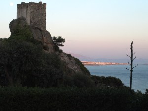 La Pena Tower within the camping grounds.  The mass of buildings on the horizon bathed in sunset light is the town of Tarifa.