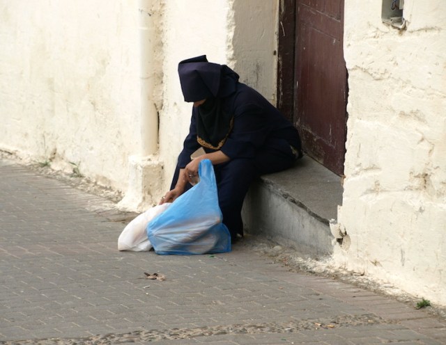 A woman having a breather on the way home from shopping. 
