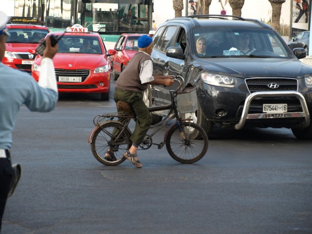 An old bloke playing chicken with Moroccan traffic. The policeman (left) and the passenger in the car abused the bike rider for getting in the way. 