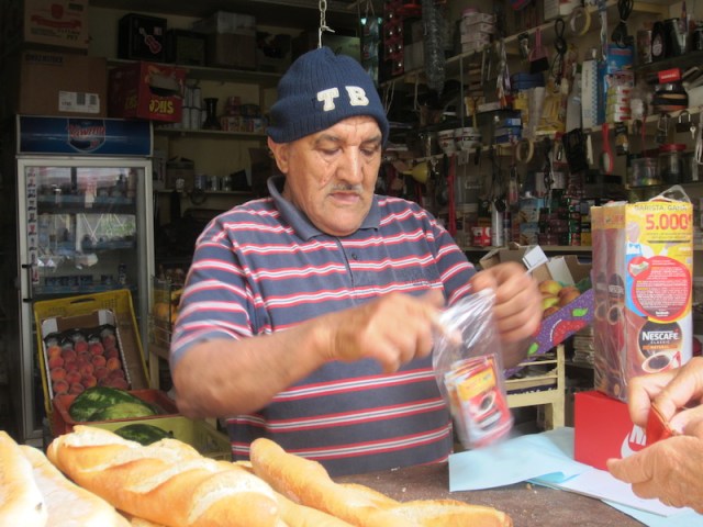 A hole-in-the-wall grocer packaging our coffee. 