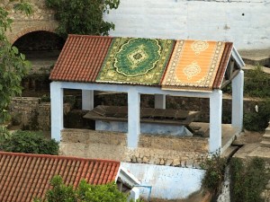Carpets slung over a roof to dry. 