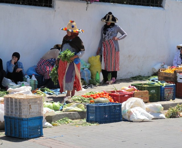 Berber women from the Rif Mountains in traditional clothing attending their vegetable stall. 