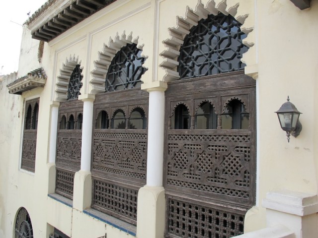 Intricately carved Moorish-style wooden window shutters above the garden. 