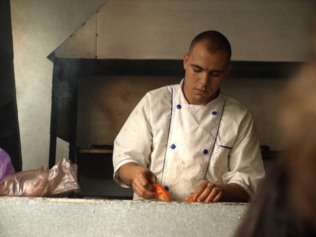 The cook who was flat out keeping up with the orders. The plastic bags on the left contain meat waiting to be cooked. 