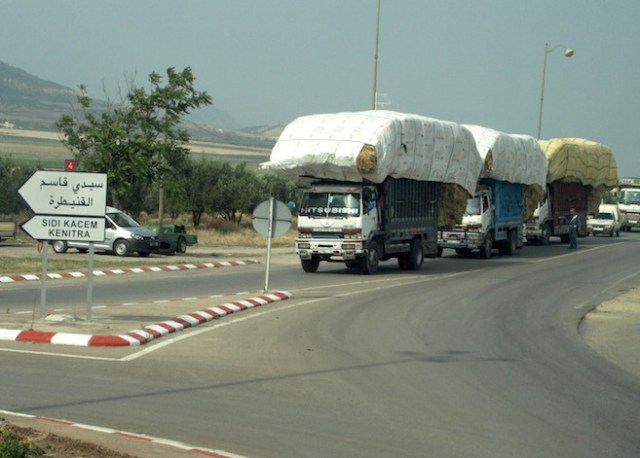 An overloaded truck carting hay. It’s a tricky load as the overhanging bails were supported by ropes only. 