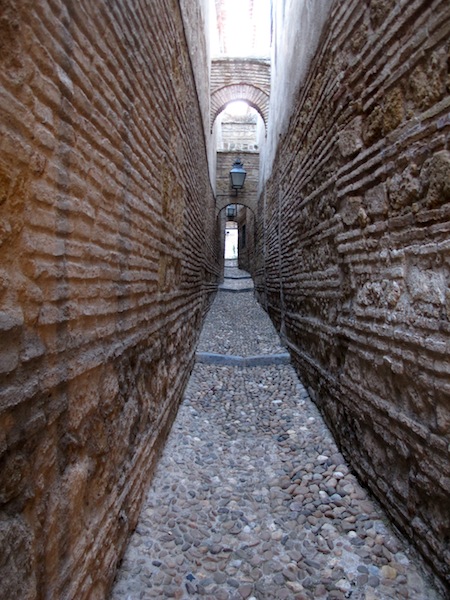 An alleyway almost too narrow for a bike. 