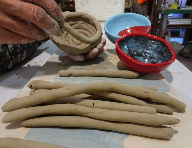 Coils of clay in the foreground, two finished coil pots and, top left, using coils to make a pot. 