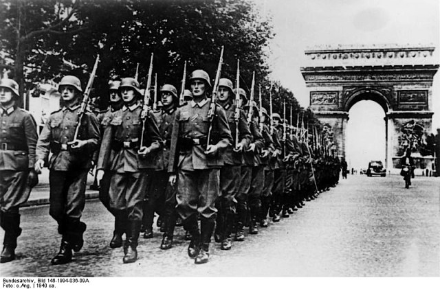 The Champs Elysees and the Arc de Triomphe 1940. German soldiers on parade. Image credit: Deutches Bundesarchiv (German Federal Archive) via Wikipedia. 