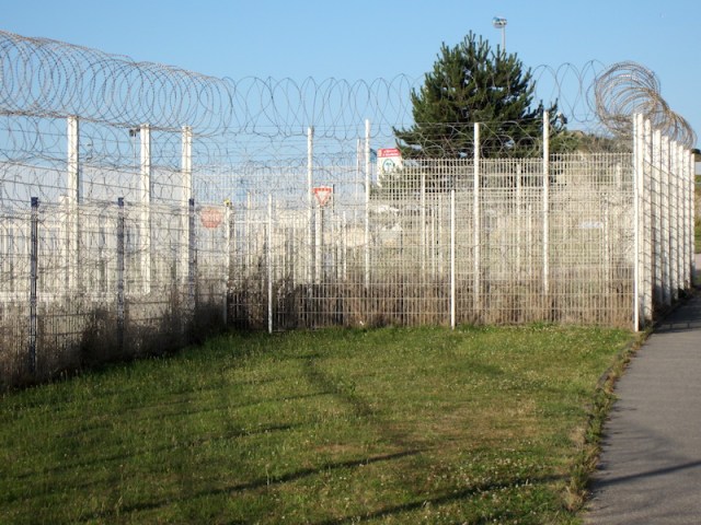 A concertina razor wire fence along the edge of the bike track to the ferry terminal, obviously erected to deter refugees seeking asylum in England. 